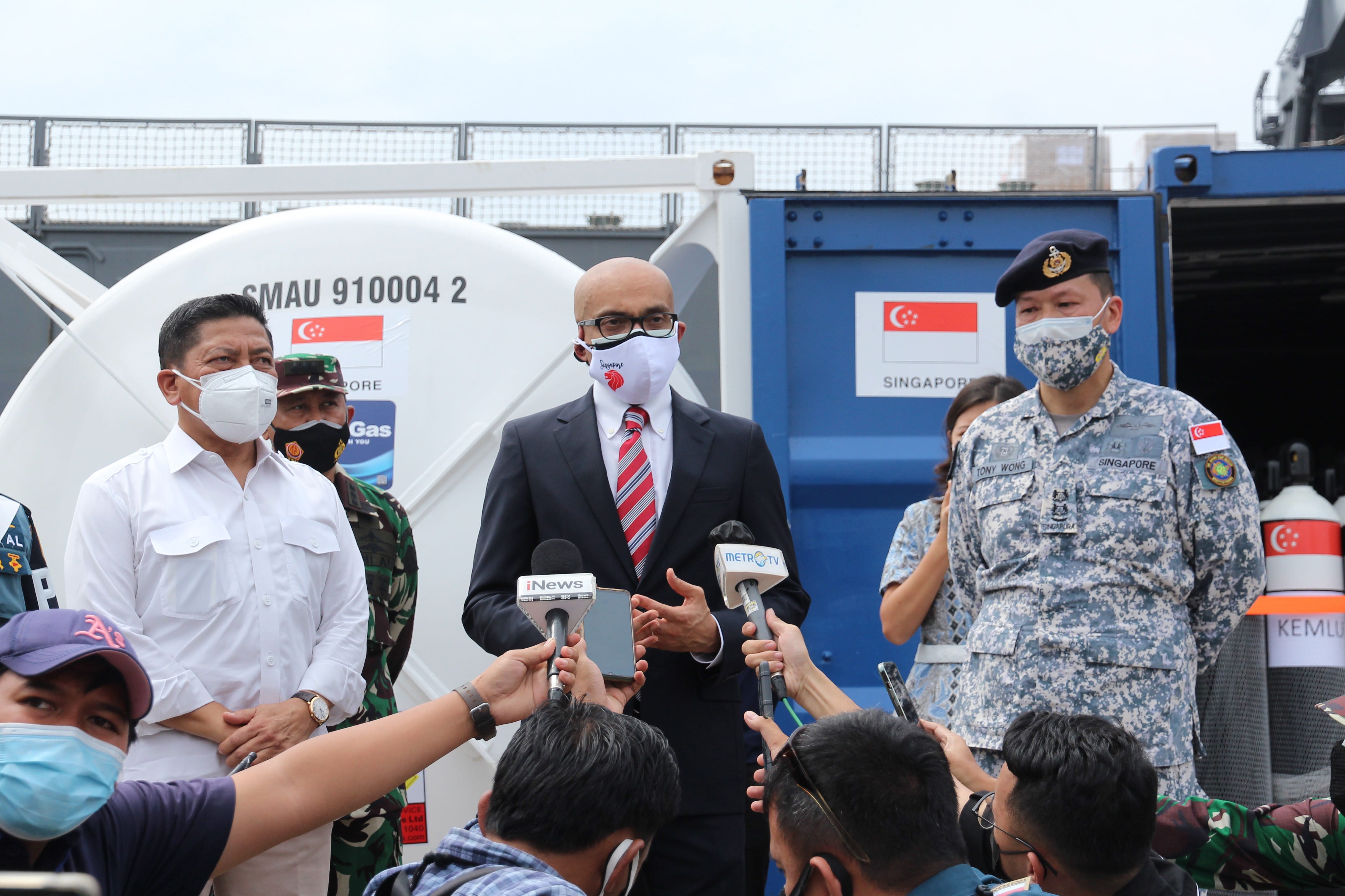 Group of seven people in business attire, standing beneath the "ERBER Group" logo and monitors showing produce.